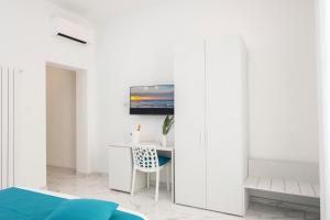 a bedroom with a bed and a desk and a tv at Fantasia House in Marsala