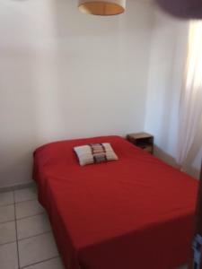 a bedroom with a red bed with a red blanket at Maria beach in San-Nicolao