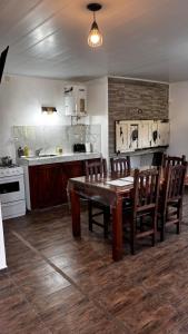 a kitchen with a wooden table and wooden chairs at ESPACIO CANELA in Ramallo +21 photos