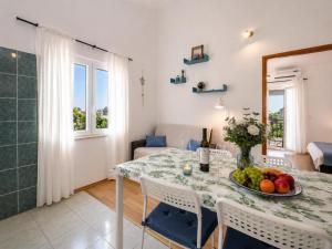 a dining room with a table with a bowl of fruit at Apartmani Bonaca in Pakoštane