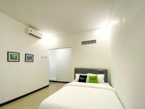 a white room with two beds in it at Urbanview Bangsal Mojokerto in Ngranggon +39 photos