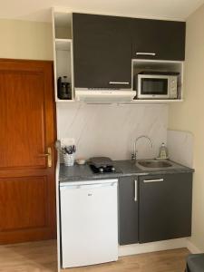 a small kitchen with a sink and a microwave at Studio Indépendant in Floirac