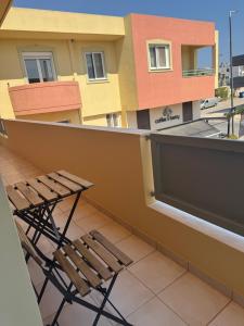 a chair on the balcony of a building at ILION Air Host - near Athens International Airport in Markopoulo