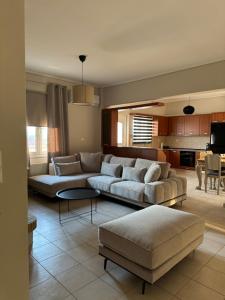 a living room with two couches and a kitchen at ILION Air Host - near Athens International Airport in Markopoulo
