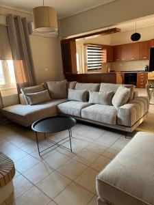a living room with a couch and a table at ILION Air Host - near Athens International Airport in Markopoulo