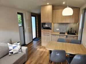 a kitchen and living room with a table and a couch at Domek Przy Jeziorze in Kujanki