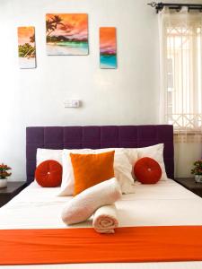 a bedroom with a bed with orange and white pillows at jennies staycation in Mombasa