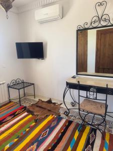 a living room with a mirror and a rug at Dar amiratou in Djerba +5 photos
