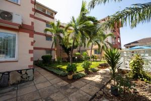 a courtyard with palm trees in front of a building at jennies staycation in Mombasa
