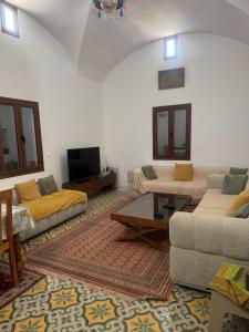 a living room with two couches and a tv at Dar amiratou in Djerba