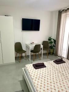 a bedroom with a bed and a table and a tv at Apartman Beli Bagrem in Veliko Gradište