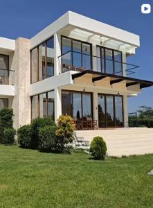 a large house with glass windows on a lawn at Flamingo Bay in Nakuru +9 photos