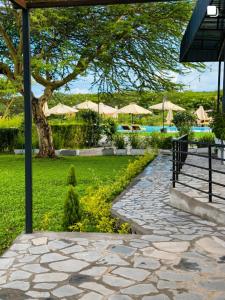 a stone walkway with umbrellas in a park at Flamingo Bay in Nakuru