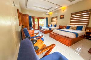 a bedroom with two beds and a couch and chairs at Mozza Beach Resort in York +37 photos