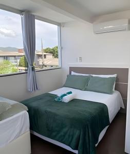 a bedroom with a bed and a window at Pousada da Mel in Florianópolis +89 photos