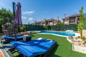 a backyard with a swimming pool and an umbrella at Charming Studio with Pool Retreat in Arroyomolinos