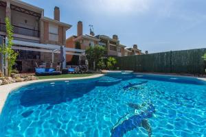 a large blue swimming pool in front of a house at Charming Studio with Pool Retreat in Arroyomolinos