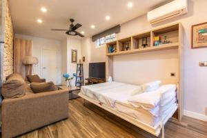a bedroom with a bed and a couch at Charming Studio with Pool Retreat in Arroyomolinos