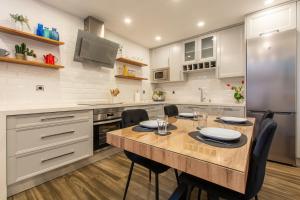 a kitchen with a table with chairs and a refrigerator at Charming Studio with Pool Retreat in Arroyomolinos +24 photos