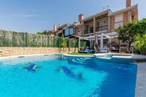 a large swimming pool in front of a house at Charming Studio with Pool Retreat in Arroyomolinos