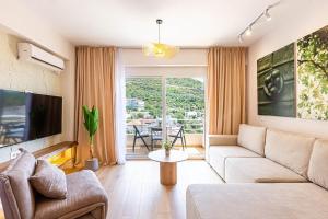 a living room with a couch and a tv at Dhermi's Icon Big 1BR Ap 15 in Dhërmi