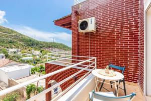 a balcony with a table and chairs on a brick building at Dhermi's Icon Big 1BR Ap 15 in Dhërmi