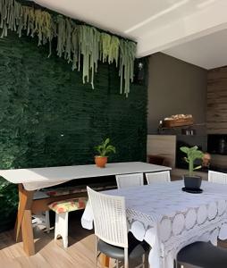 a dining room with a table and a green wall at Pousada da Mel in Florianópolis