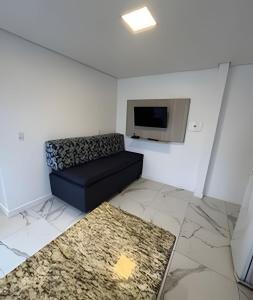 a living room with a couch and a tv at Pousada da Mel in Florianópolis