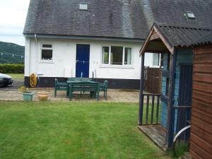 a house with a picnic table in the yard at Feochan View in Oban