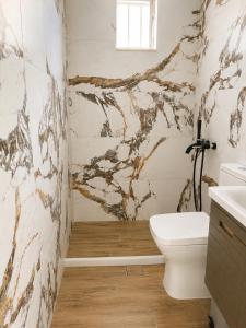 a bathroom with a white toilet and a sink at Retro Apartment Patras in Patra +14 photos