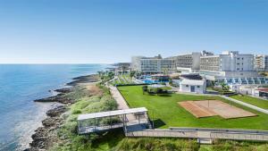 ein Haus am Meeresufer mit Tennisplatz in der Unterkunft Pernera Beach Hotel in Protaras