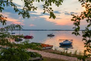 a group of boats on a lake at sunset at Apartament Joanna in Szczedrzyk