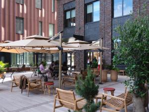 an outdoor patio with tables and chairs and umbrellas at Belle Guldsmeden in Aarhus