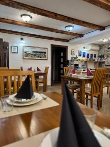 a dining room with wooden tables and chairs and a kitchen at B&B Millenium House in Plitvička Jezera