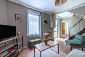 a living room with a tv and a couch at Brise Lavalloise - Wifi - Centre Ville in Laval
