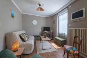 a living room with a couch and a tv at Brise Lavalloise - Wifi - Centre Ville in Laval