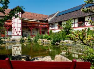 ein Gebäude mit einem Teich davor in der Unterkunft Hotel Gut Voigtlaender in Blankenburg
