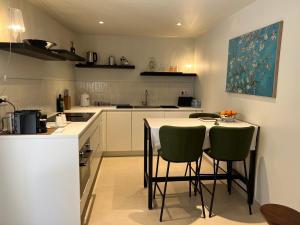 a kitchen with a table and two green chairs at DURANCE in La Brillanne