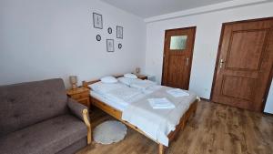 a bedroom with a bed and a couch at Pensjonat Fluder in Jaszczurowa