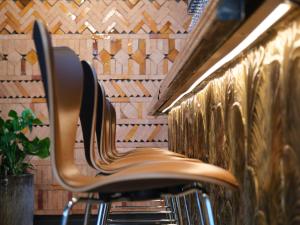 a brown chair sitting next to a wall at Belle Guldsmeden in Aarhus +31 photos
