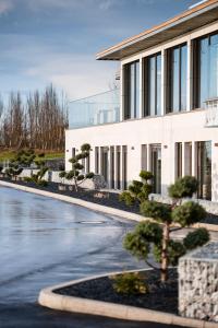 a building with trees in front of a road at Hotel TheGreen ehemals Köln11 in Cologne