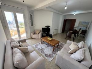a living room with a couch and a table at Equipped apartment with elevator, sea view in Bordj el Bahri