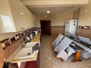 a kitchen with a sink and a counter and a refrigerator at Equipped apartment with elevator, sea view in Bordj el Bahri +17 photos