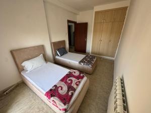 a small room with two beds in it at Equipped apartment with elevator, sea view in Bordj el Bahri
