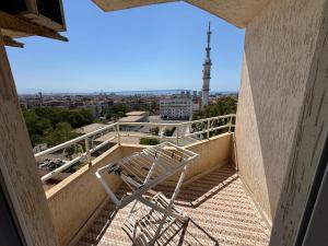 a chair sitting on the balcony of a building at Equipped apartment with elevator, sea view in Bordj el Bahri