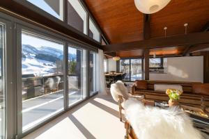 ein Wohnzimmer mit Fenstern und Blick auf die Berge in der Unterkunft Alpstern in Wildhaus