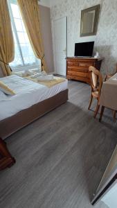a bedroom with a bed and a desk and a television at La Granitiere Maison de Charme in Saint-Vaast-la-Hougue +37 photos