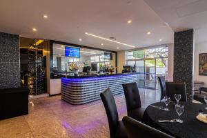 a restaurant with tables and chairs and a bar at Afrin Prestige Hotel in Maputo