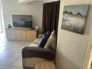 a living room with a couch and a television at Dockside in Port Alfred