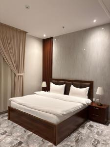 a bedroom with a large bed with white sheets and pillows at بريفير للشقق المخدومة - Privere Serviced Apartments in Riyadh